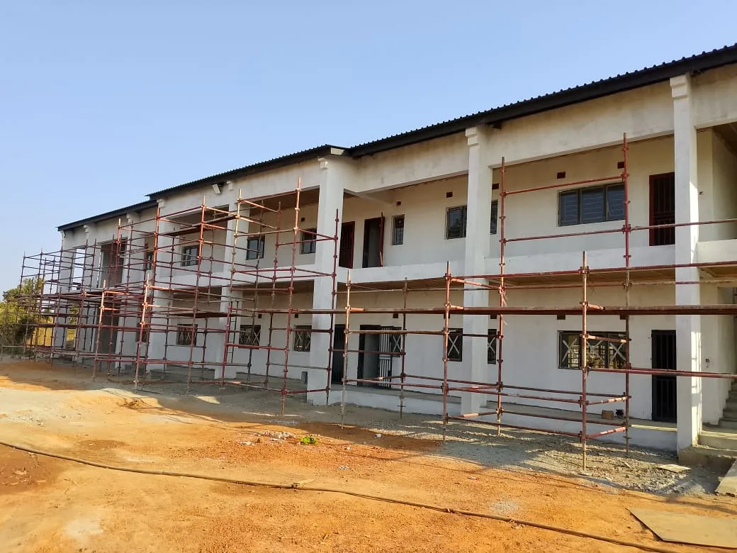 Double-storey classroom block under construction with scaffolding, built by Ulmart Zambia